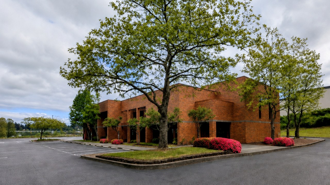 Brick commercial office building with surrounding parking and landscaping